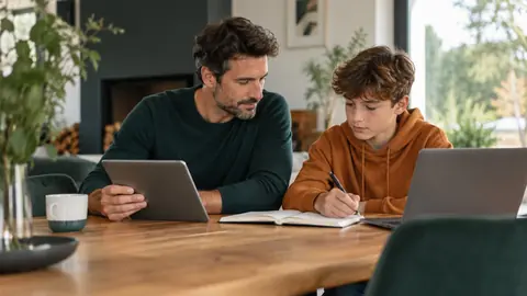 Parent et préadolescent avec leurs appareils respectifs à une table
